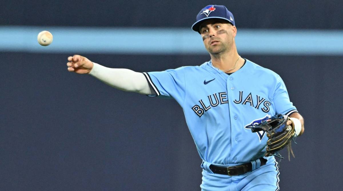 Blue Jays infielder Whit Merrifield throws a ball in a game.